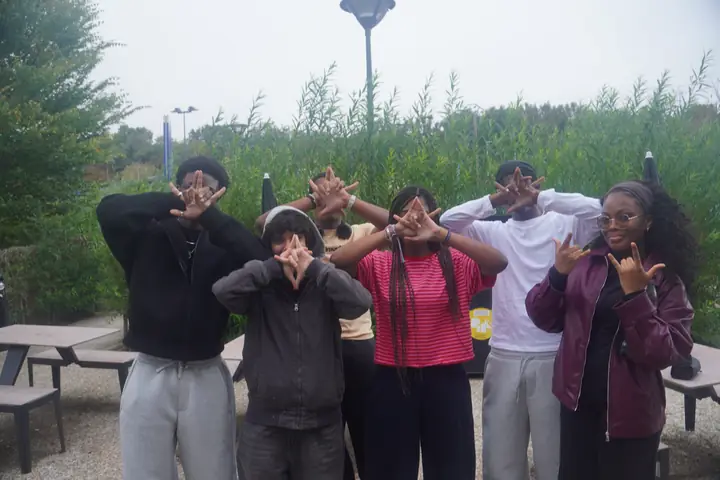 Un groupe d'amis fait des signes de la main dehors