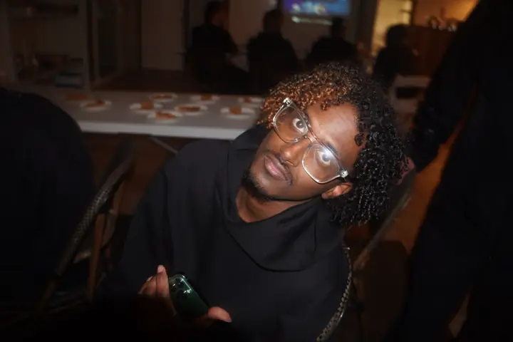 Un étudiant à lunettes sourit à l'objectif