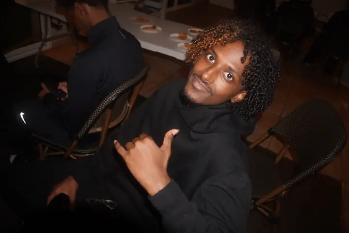 Un étudiant fait un signe shaka