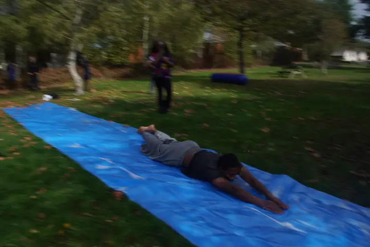 Un étudiant allongé sur la bâche glissante
